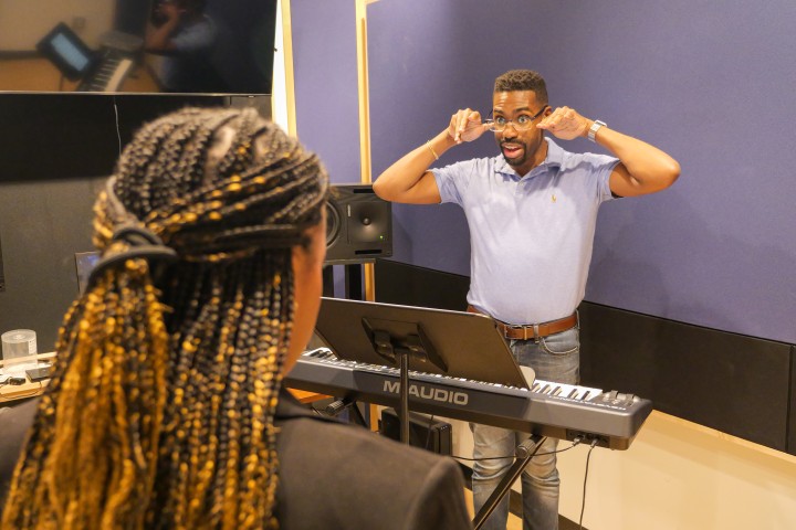 a music instructor and participant rehearsing.
