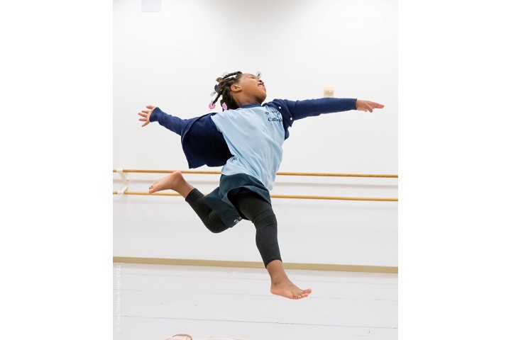 a child dancing in a ballet room.