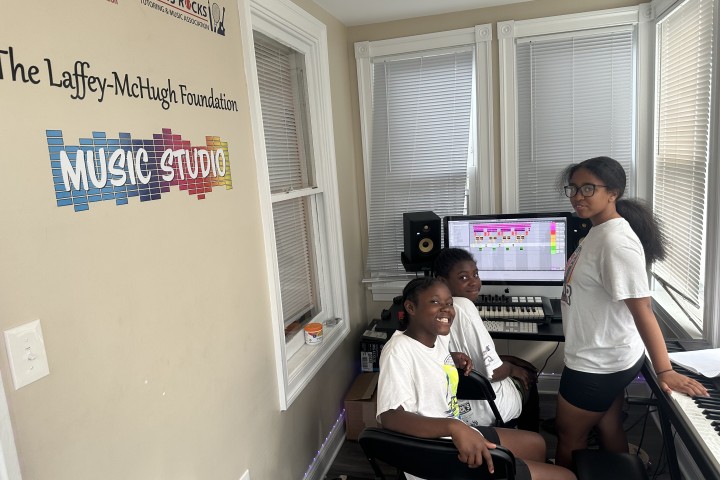 students sitting in a music library room at camp.