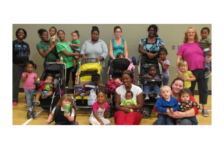 mothers and their children's posing in front of strollers in a community shelter
