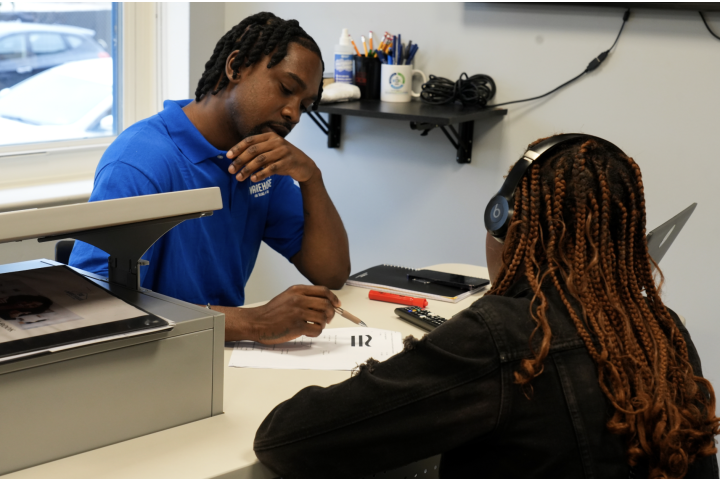 A worker and teenager sitting at a desk