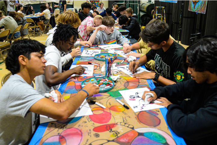 teens painting at a long table